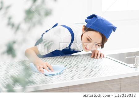 A woman from a housekeeping service cleaning the kitchen A woman from a housekeeping service cleaning the kitchen 118019038