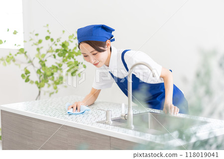 A woman from a housekeeping service cleaning the kitchen A woman from a housekeeping service cleaning the kitchen 118019041