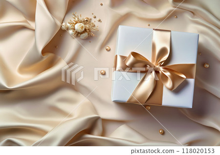 絲綢織物上放置的金色絲帶禮盒 118020153