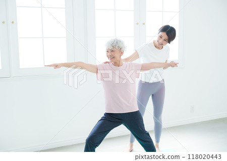 Senior woman doing yoga and instructor 118020443