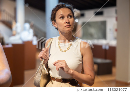Woman visit museum, examines masterpiece at exhibition Woman visit museum, examines masterpiece at exhibition 118021077