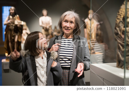 Preteen girl visiting museum of ancient sculpture her grandmother 118021091