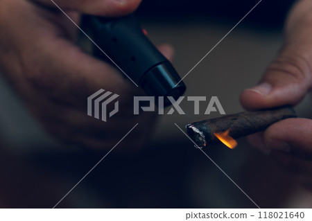 Close-up of a hand lighting a cigar Close-up of a hand lighting a cigar 118021640