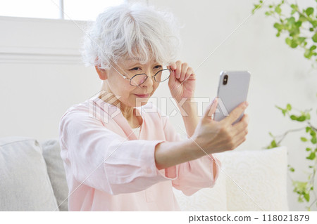 看智慧型手機的老花眼高級女性 118021879