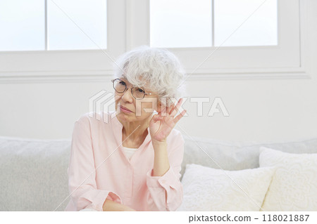 Hearing-impaired senior woman in the living room 118021887