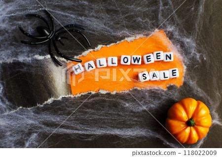 curl of torn black paper on orange background. halloween sale concept 118022009