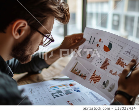 Entrepreneur reviewing a detailed business plan with graphs and charts, business strategy visualizat 118022434