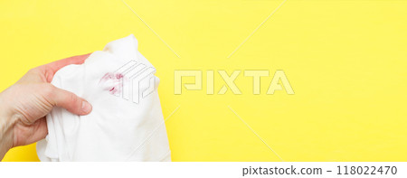 Woman holding a white shirt with red kiss lipstick on a yellow background Woman holding a white shirt with red kiss lipstick on a yellow background 118022470