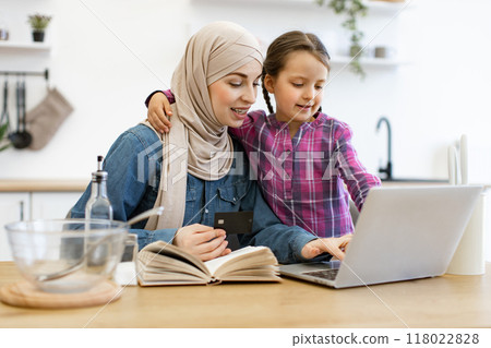 Muslim mother and daughter shopping online for cooking ingredients using laptop Muslim mother and daughter shopping online for cooking ingredients using laptop 118022828