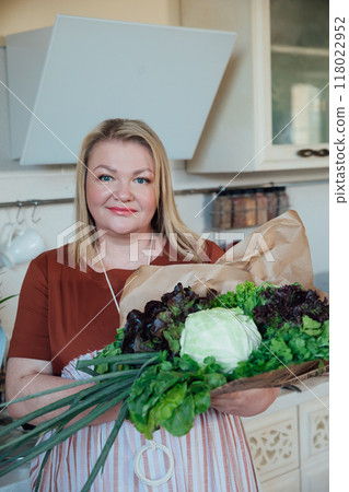 Woman with a bag of fresh vegetables for cooking in the kitchen 118022952