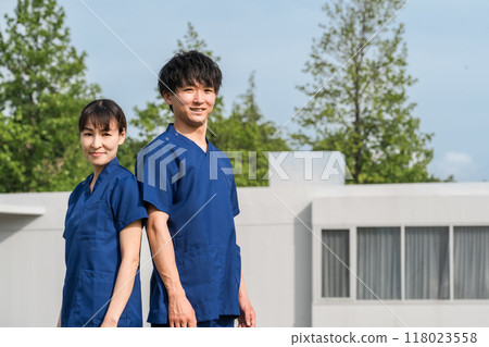 醫院或醫療機構前穿著工作服的男女醫護人員（職能治療師和護士） 118023558