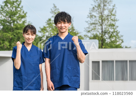 醫院和設施前穿著手術服的男女醫護人員（護士、護理人員、護理人員） 118023560