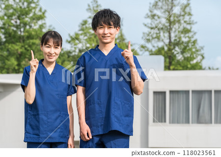 醫院和設施前穿著手術服的男女醫護人員（職能治療師、護士） 118023561