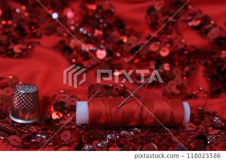 Red Beaded Fabric With Spool of Thread and Thimble Red Beaded Fabric With Spool of Thread and Thimble 118023586
