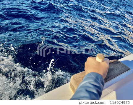 Human hand with the view of the sea from the boat on the background of the waves. 118024975