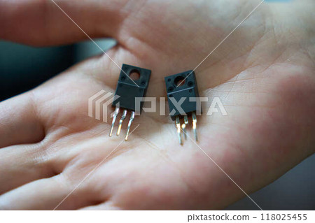 Close up of a semiconductor transistor on a hand Close up of a semiconductor transistor on a hand 118025455