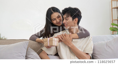 Young couple exchanging a thoughtful gift at home 118025657