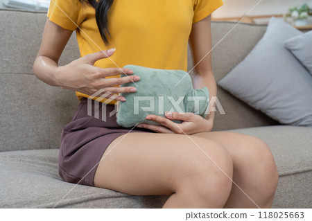Soothing menstrual pain with a hot water bottle Soothing menstrual pain with a hot water bottle 118025663