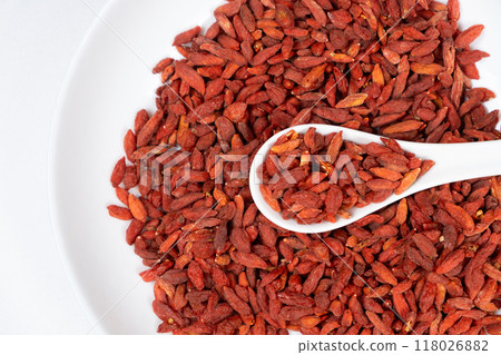 Dried Goji berries Lycium barbarum in a spoon top view on a white background Dried Goji berries Lycium barbarum in a spoon top view on a white background 118026882