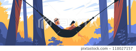Man relaxing in hammock between trees reading book in forest with vibrant foliage and clear sky 118027157