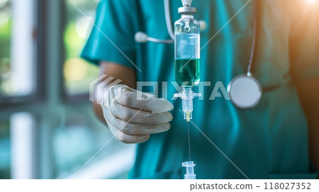 Medical professional adjusting an IV drip in a clinical setting. 118027352