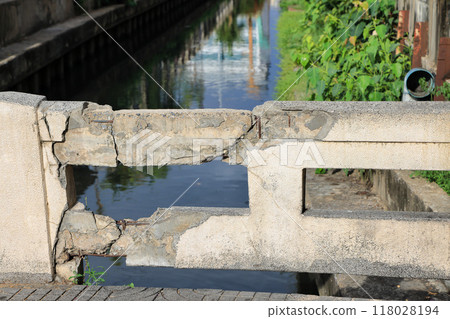 Cracked grey concrete surface with visible reinforcement, Rust in reinforcement of Concrete bridge, Broken or weak concrete. Cracked grey concrete surface with visible reinforcement, Rust in reinforcement of Concrete bridge, Broken or weak concrete. 118028194