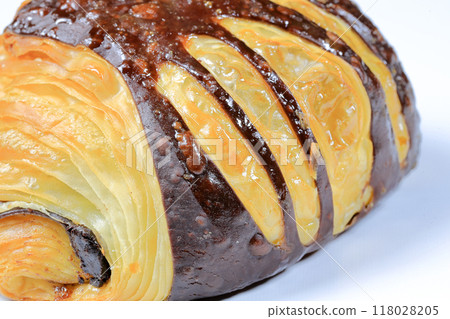 Close up Freshly baked croissant, Chocolate Praline croissant isolated on white background. French pastry closeup photo. Buttered bread croissant. 118028205