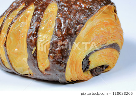 Close up Freshly baked croissant, Chocolate Praline croissant isolated on white background. French pastry closeup photo. Buttered bread croissant. 118028206