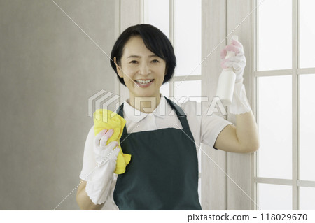 Housekeeping service: Portrait of a middle-aged female staff member holding a rag and spray Housekeeping service: Portrait of a middle-aged female staff member holding a rag and spray 118029670