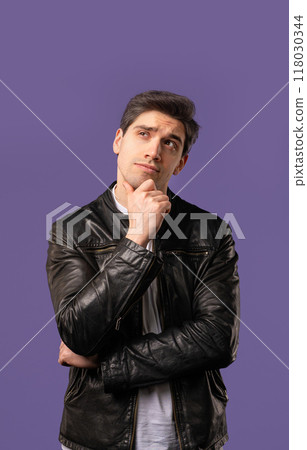 Portrait of curious analyzing man in violet studio. Mindful guy finding solution Portrait of curious analyzing man in violet studio. Mindful guy finding solution 118030344