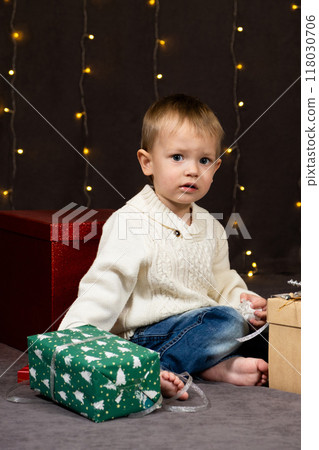 Little two-year-old boy opens Christmas gifts at home 118030706