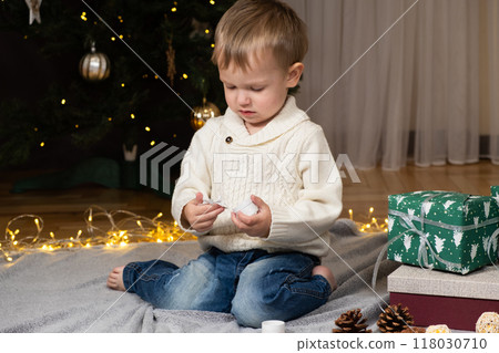 Little two-year-old boy opens Christmas gifts at home 118030710