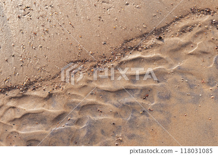 Wet sand ripples and peddle on the beach, top view. Abstract photo 118031085