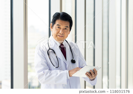 A senior doctor operating a tablet. Photo courtesy of Denpa Gakuen, Tokyo Electronics College. 118031576
