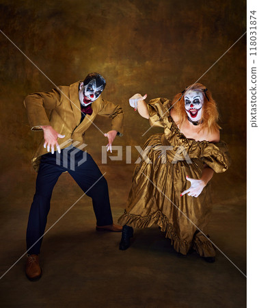 Clowns, dressed in vintage attire, striking comical poses together, with wide smiles and exaggerated gestures against vintage backdrop. 118031874
