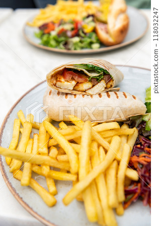 Halloumi wraps with salad and french fries Halloumi wraps with salad and french fries 118032247