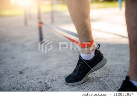 Male legs training with elastic rubber 118032934