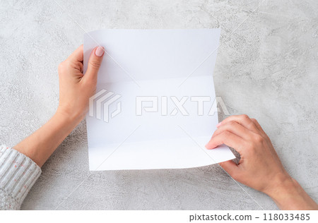 Girl's hands holding sheet of paper 118033485