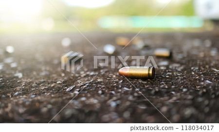 Spent bullet casing lying on dark ground with blur number 2 sign. Concepts of criminal investigations 118034017