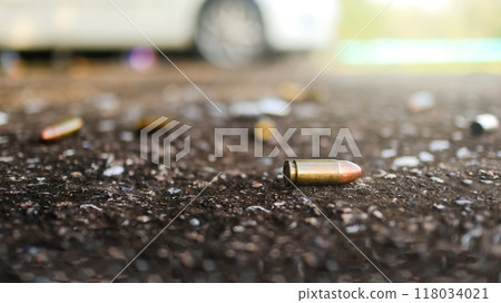 Spent bullet casing lying on dark ground with blur background. Concepts of criminal investigations Spent bullet casing lying on dark ground with blur background. Concepts of criminal investigations 118034021