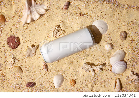 Aluminum can on sandy beach, surrounded by seashells, creating refreshing image for drinks advertisement. Aluminum can on sandy beach, surrounded by seashells, creating refreshing image for drinks advertisement. 118034341