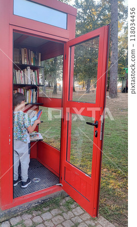 Toddler boy sitting in a crossbooking booth and reading a book. Self-education concept for children, Education concept, prep or elementary school. Toddler boy sitting in a crossbooking booth and reading a book. Self-education concept for children, Education concept, prep or elementary school. 118034456