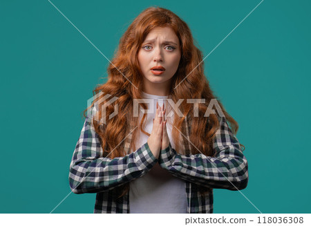 Young woman praying, begs to apologize her, she is guilty. Blue background. Hopeful prayer girl asking someone satisfy her desires, help with Young woman praying, begs to apologize her, she is guilty. Blue background. Hopeful prayer girl asking someone satisfy her desires, help with 118036308
