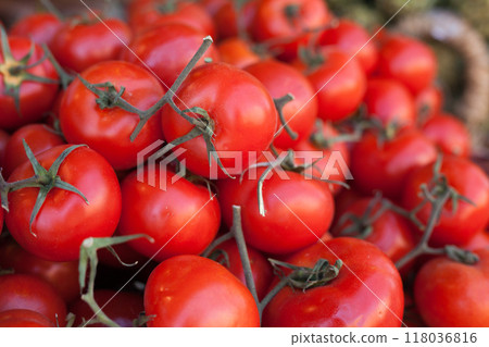 Red fresh tomatoes on branch in wicker baskets on counter 118036816