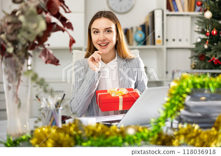 Young woman office worker with gift box during Christmastime 118036918