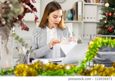 Portrait of happy female manager with money in an envelope - christmas present 118036971