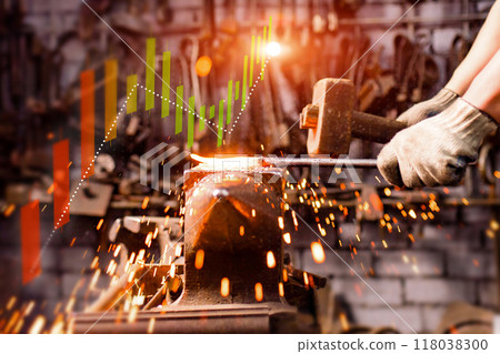 A person is hammering a piece of metal in front of a graph that shows a downward A person is hammering a piece of metal in front of a graph that shows a downward 118038300