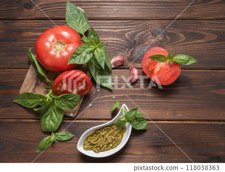 Basil pesto, fresh basil leaves, tomatoes and garlic on wooden background. ingredients for cooking. Basil pesto, fresh basil leaves, tomatoes and garlic on wooden background. ingredients for cooking. 118038363