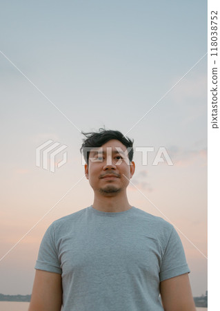 Portrait of man standing with smooth colorful sunset sky. 118038752