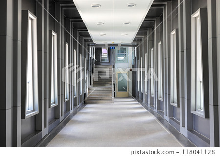 Pedestrian pathway or corridor or hallway between train station and other building. 118041128